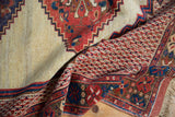 Intricate ribboned and floral motifs in the multi-banded border of a hand-knotted antique Afshar rug.