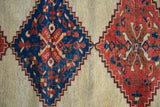 Stepped serrated medallions in sapphire blue and red on the ivory field of an antique Afshar rug.