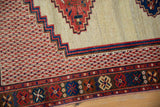 Detail of the antique Afshar rug's colorful floral border and stepped geometric bands.