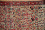 Antique Zuli Sultan rug, fine wool pile with even wear, featuring red border, ivory floral field.