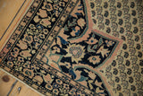 Close-up of antique Farahan Sarouk corner, navy spandrel, ivory field with boteh motifs.
