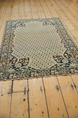Close-up of antique rug's corner: rich navy floral spandrel with blush and teal details.
