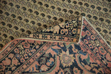Antique Farahan Sarouk rug curled detail: ivory germinating boteh field and navy floral border.