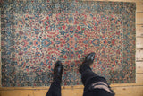Vintage Kerman rug with detailed millefleur and palmette design in ivory, rose, and blue tones.
