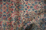 Softened ivory and pale blush millefleur design on a vintage Kerman rug pile.
