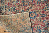 Vintage Kerman rug's ivory millefleur pile and finely hand-knotted foundation in peach and blue.