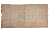 Vintage Oushak rug with a floral blossom pattern in dusty rose and saffron on an ivory background.