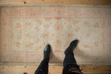 A perspective view of the vintage Oushak's hand-knotted texture and mostly even, low pile.