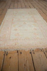 A low-angle view highlighting the even wear and pile texture of a vintage Turkish Oushak rug.