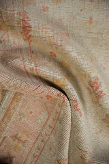 Low, hand-knotted pile of a vintage Oushak rug, showing mostly even wear to its knot heads.
