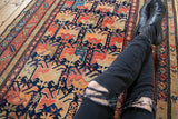 Antique Karabagh runner: hand-knotted geometric field of blossoms, birds, navy, red, orange.