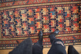 Overhead view of an antique Karabagh runner showcasing geometric motifs in navy, red, and tangerine.