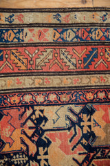 Antique Karabagh runner's geometric bands with stylized animal motifs in navy, red, and beige.