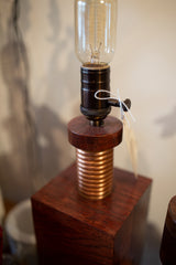 Square oak wood base and hand-twisted copper coil of the Edison lamp.