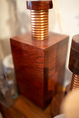 Corner detail of rich solid oak wood grain and hand-formed copper coils.