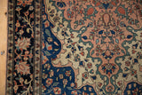 Indigo blue border, floral vinery, and dusty blush field of an Antique Farahan Sarouk rug.