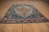 Antique Farahan Sarouk rug corner, indigo field with delicate floral vinery, intact selvage.