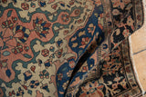 Exquisite pinwheel floral petals and delicate vinery on a folded antique Farahan Sarouk.