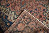 Folded antique Farahan Sarouk rug revealing indigo border with delicate floral vinery.