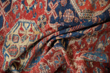 Hand woven antique Soumac carpet displaying cherry red, navy, ivory floral motifs and exposed foundation.