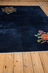 Side cord selvage and corner floral bouquet on a navy blue vintage Nichols Art Deco rug.