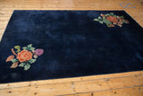 Art Deco floral bouquet with orange, violet, and green on a deep navy blue pile.