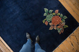 Deep cobalt blue field of vintage Nichols Art Deco rug with corner floral design.