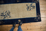 Vintage Peking rug corner, cobalt blue border, beige field with tree motif, and fringe.