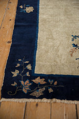 Vintage Peking rug corner with cobalt blue border, antique ivory field, and intricate floral vines.