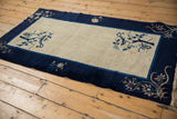 Vintage Peking rug's cobalt blue border with ornate floral, curvilinear vine motifs, and fringe.
