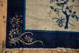 Vintage Peking rug corner with cobalt blue border, floral vine design, and ivory fringe.
