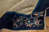 Vintage Peking rug's cobalt blue border with colorful foliage motifs, light beige field, and fringe.