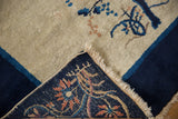 Corner of vintage Peking rug folded, revealing hand-knotted foundation, fringe, and intact selvage.