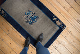 Vintage Peking rug corner with indigo border, light blue stripe, and beige floral motifs.