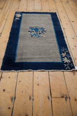 Vintage Peking rug corner with hand-knotted fringe, indigo border, and beige floral motif.