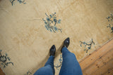 Antique Peking rug with a cream and pale gold field, featuring powder blue floral branches.