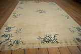 Delicate blue floral branches on cream field, antique Peking rug end with fringe detail.