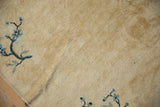 Antique Peking rug corner with blue floral branches, ivory field, and intact selvage.