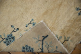 Hand-knotted foundation of antique Peking rug revealing cream pile and blue floral branches.