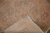Lifted corner of the vintage Amritsar runner shows muted floral pile with faint foundation.
