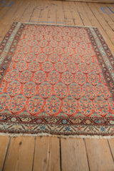 Brick red vintage Malayer rug with allover boteh motif, showing even pile wear and tattered fringe.