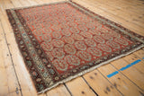 Vintage Malayer rug corner with detailed floral borders, brick red boteh pattern, and tattered fringe.