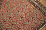 Brick red Malayer rug field with staggered blue, blush boteh and ornate dark border.
