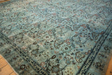 Distressed Meshed carpet detail: Arts and crafts inspired dusty blue floral motifs, pronounced pile wear.