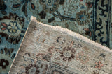 Distressed blue pile with Arts and crafts motifs, visible hand-knotted foundation and fringe.