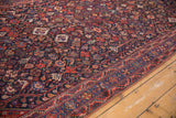 Vintage Shiraz rug: detailed border of blue medallions and red motifs on dense navy field.