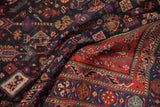 Vintage Shiraz rug runner detail: navy blue field, geometric forest patterns, red border.