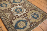 Distressed texture of vintage Hamadan rug showing faint foundation, cobalt pinwheel, and pearl border.