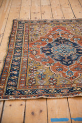 Corner detail of a vintage Heriz rug's meandering vine and floral pinwheel border.