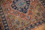 Angled view showing even wear across the knot heads on the rug's gold and navy corner.